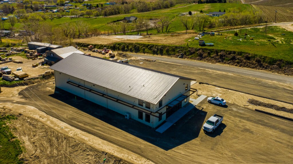 Aerial view of rural warehouse surrounded by greenery.