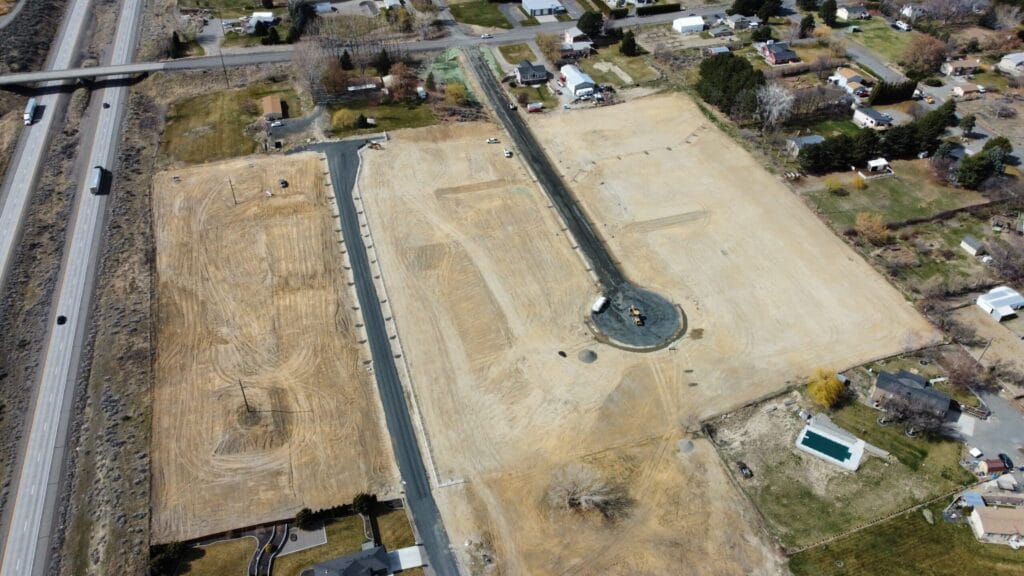 Aerial view of construction site with nearby highway.
