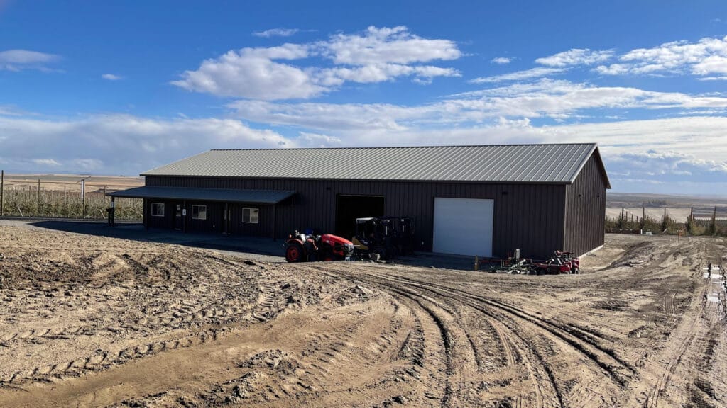 Large barn with tractor on muddy ground