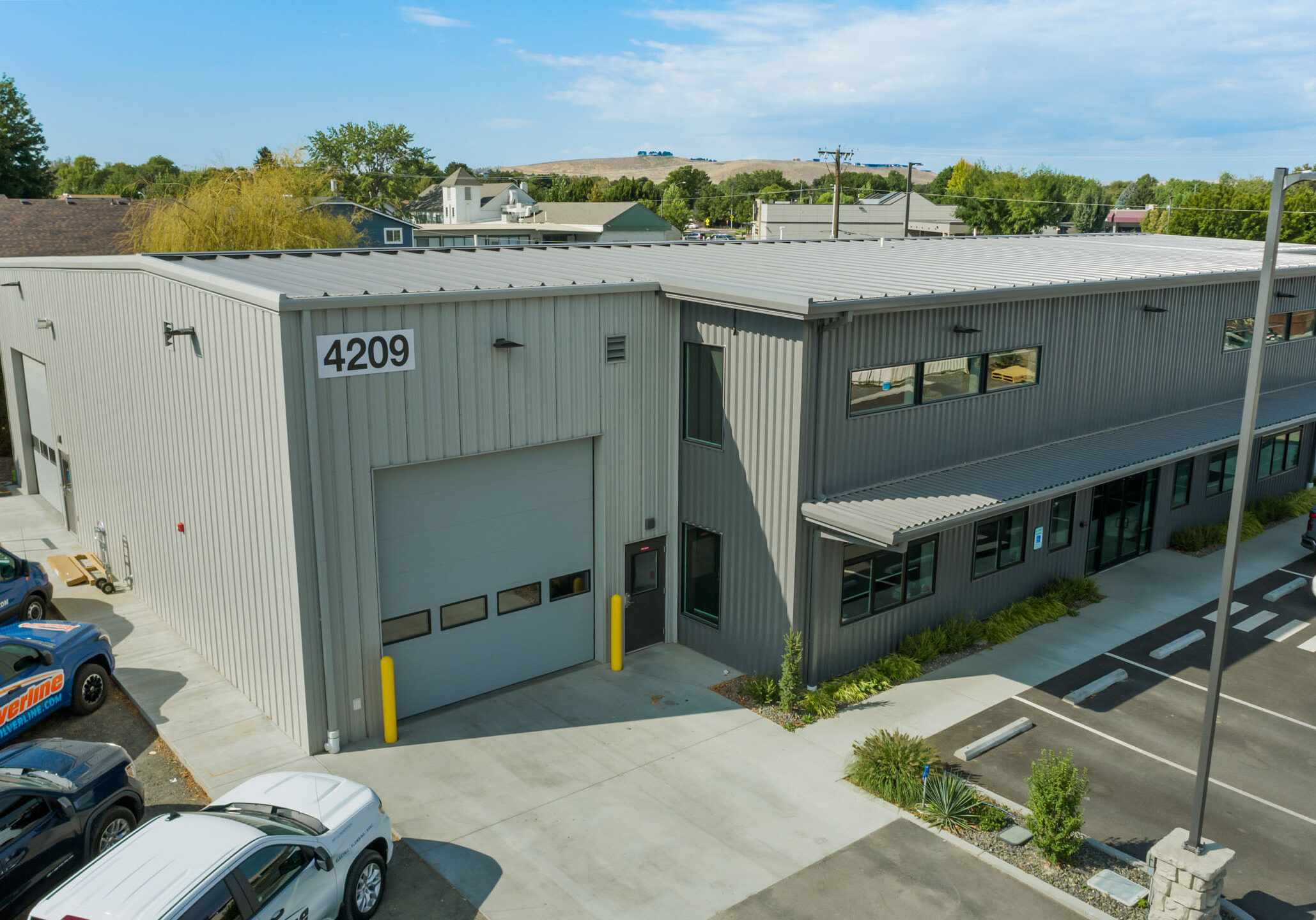 Industrial building with parking area and company vans.