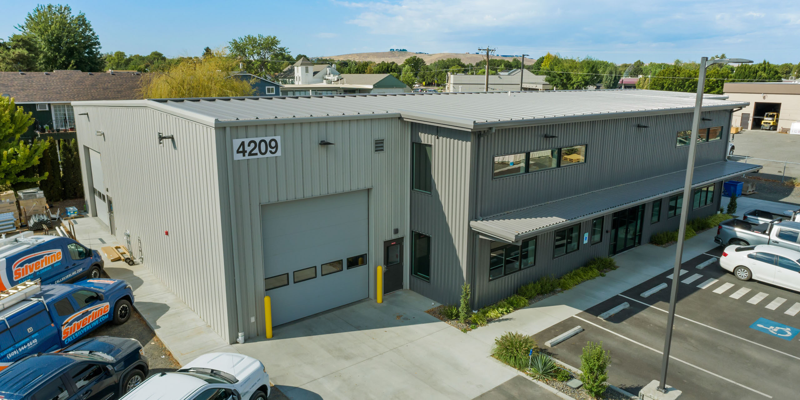 Industrial building with parking area and company vans.