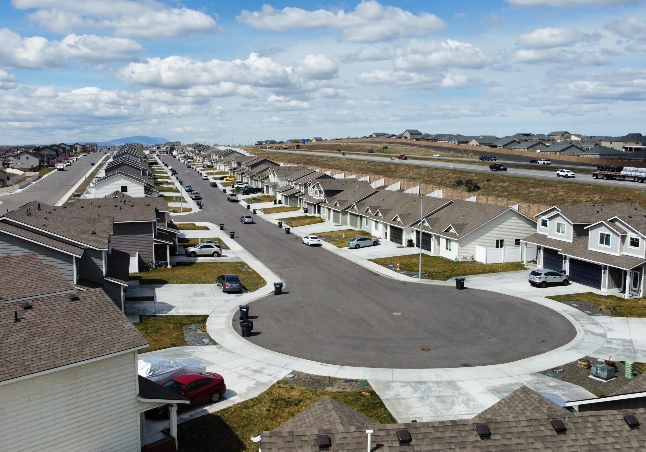 Suburban neighborhood with cul-de-sac and parked cars.