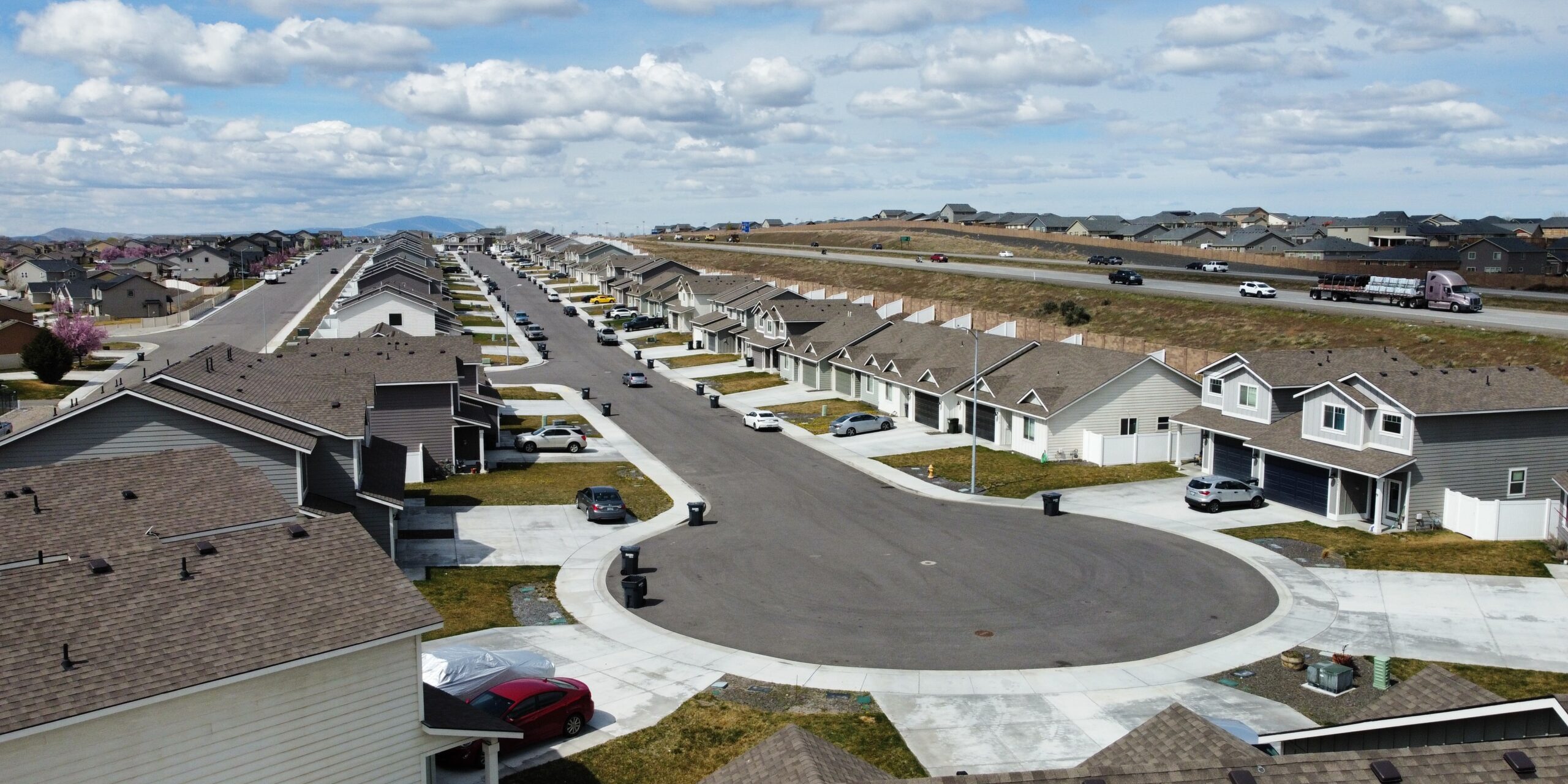 Suburban neighborhood with cul-de-sac and parked cars.