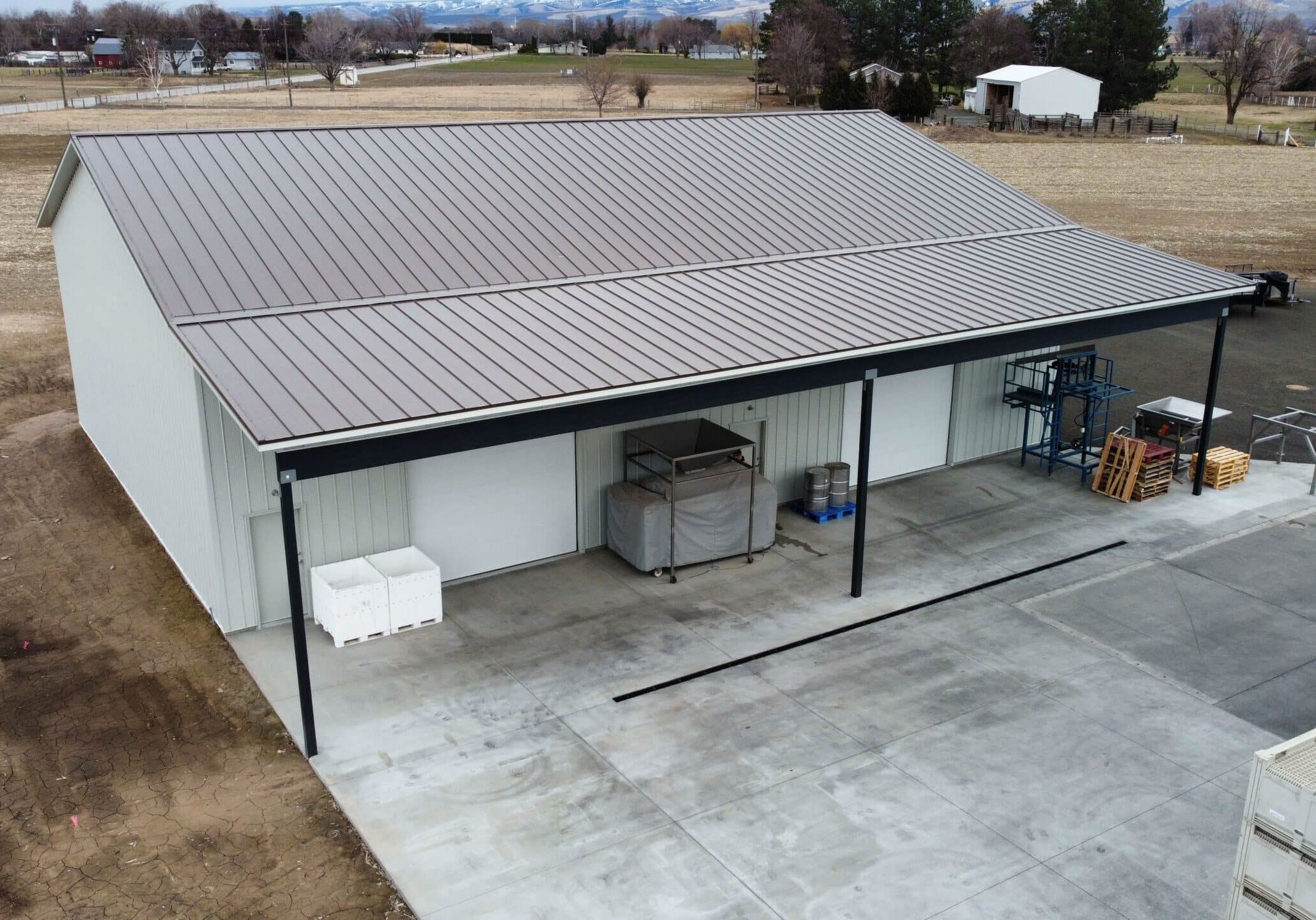 Rural storage building with metal roof and crates.
