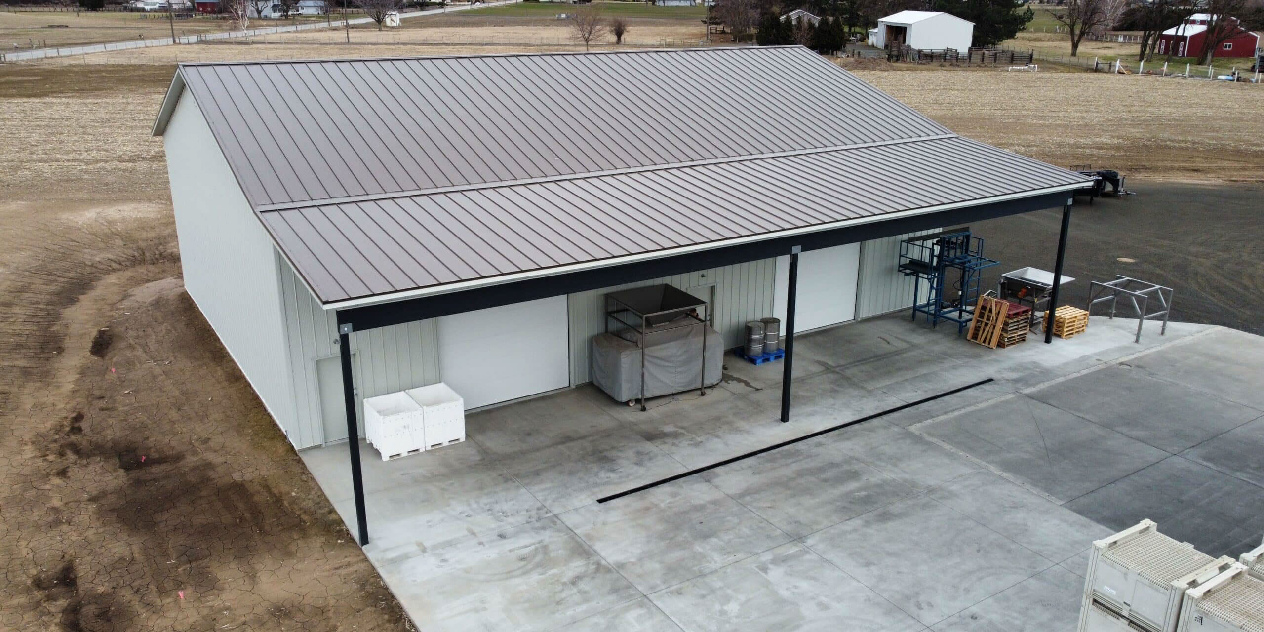 Rural storage building with metal roof and crates.