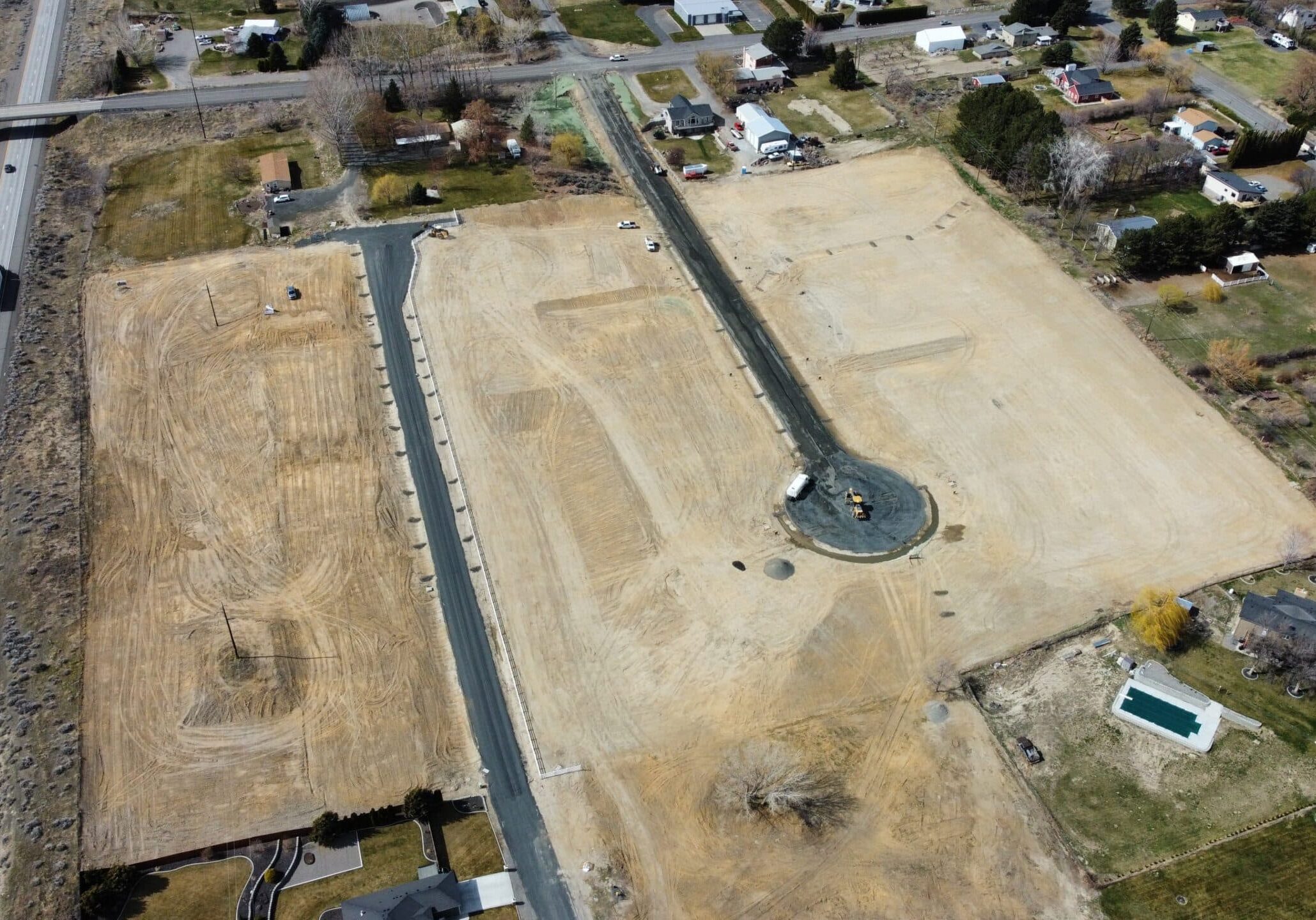 Aerial view of construction site with nearby highway.