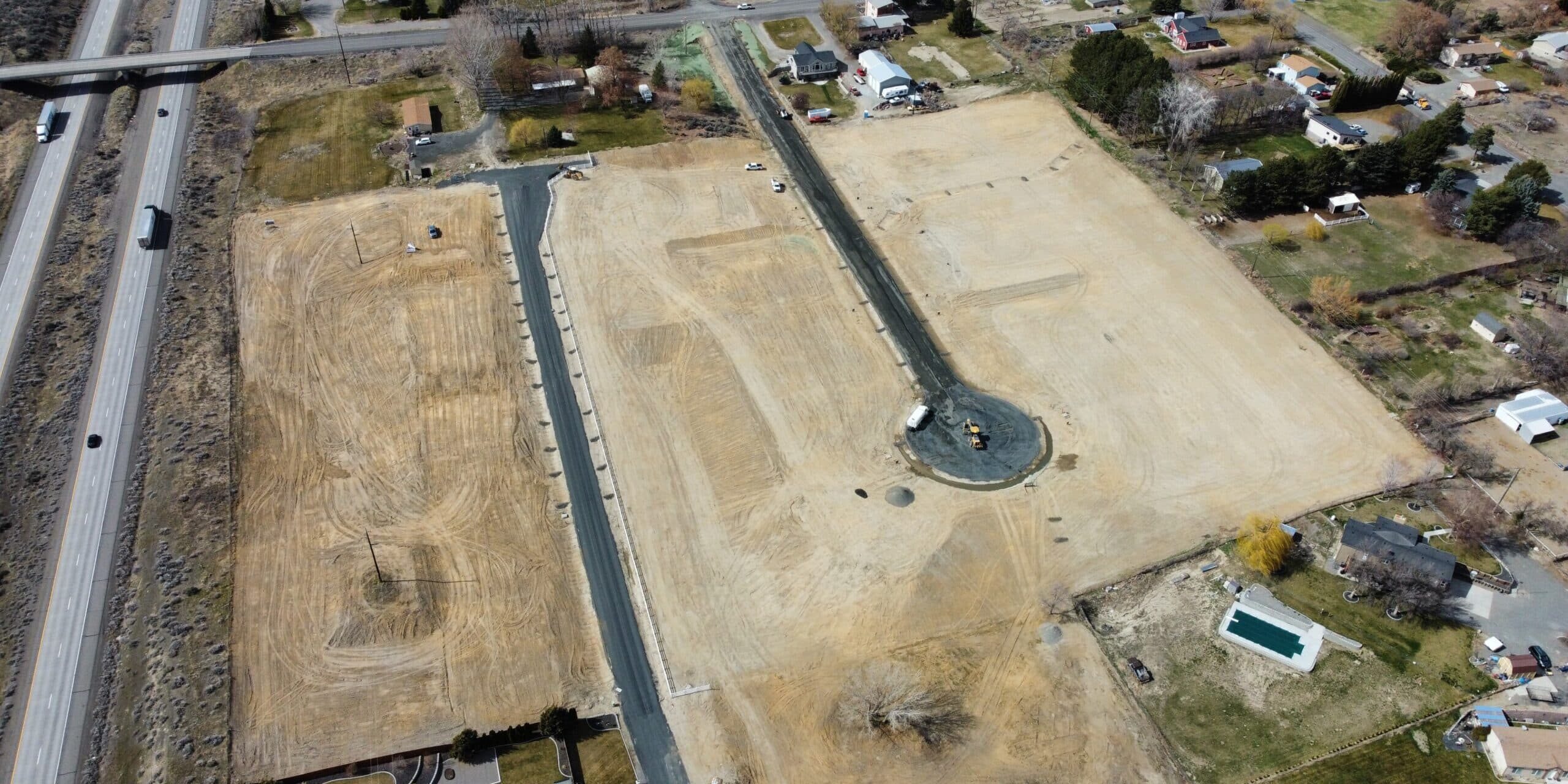 Aerial view of construction site with nearby highway.